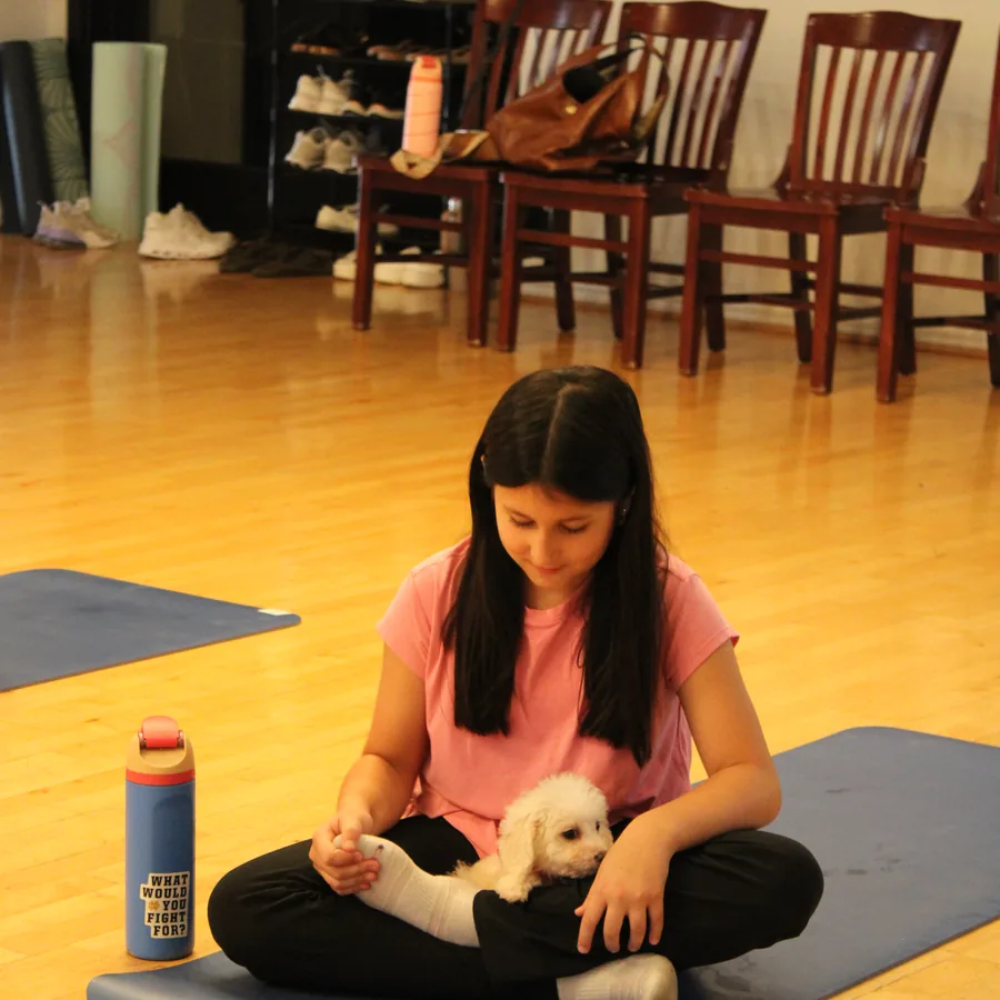 Guest on a yoga mat with a puppy at Pawty Yoga Houston