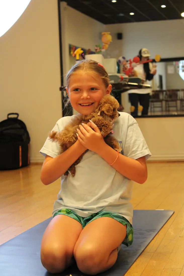 Guests laughing with puppies at a private Pawty Yoga event in Houston