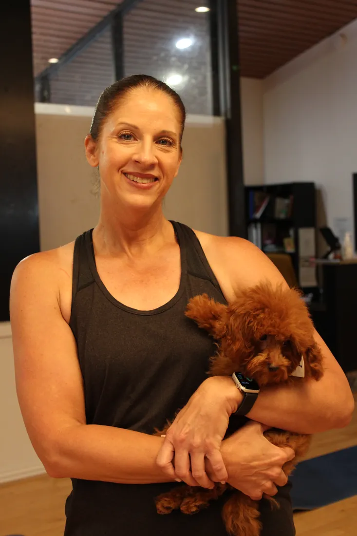 Guest holding her puppy at Pawty Yoga Houston in the Memorial area