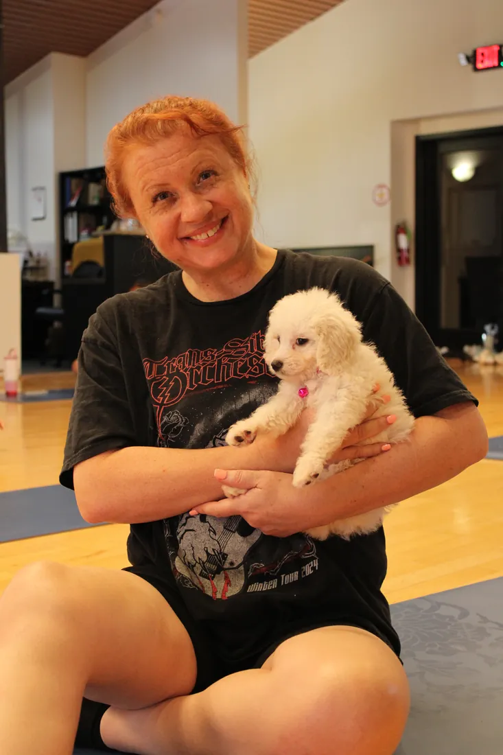 Guest cuddling a fluffy puppy at Pawty Yoga Houston's grand opening