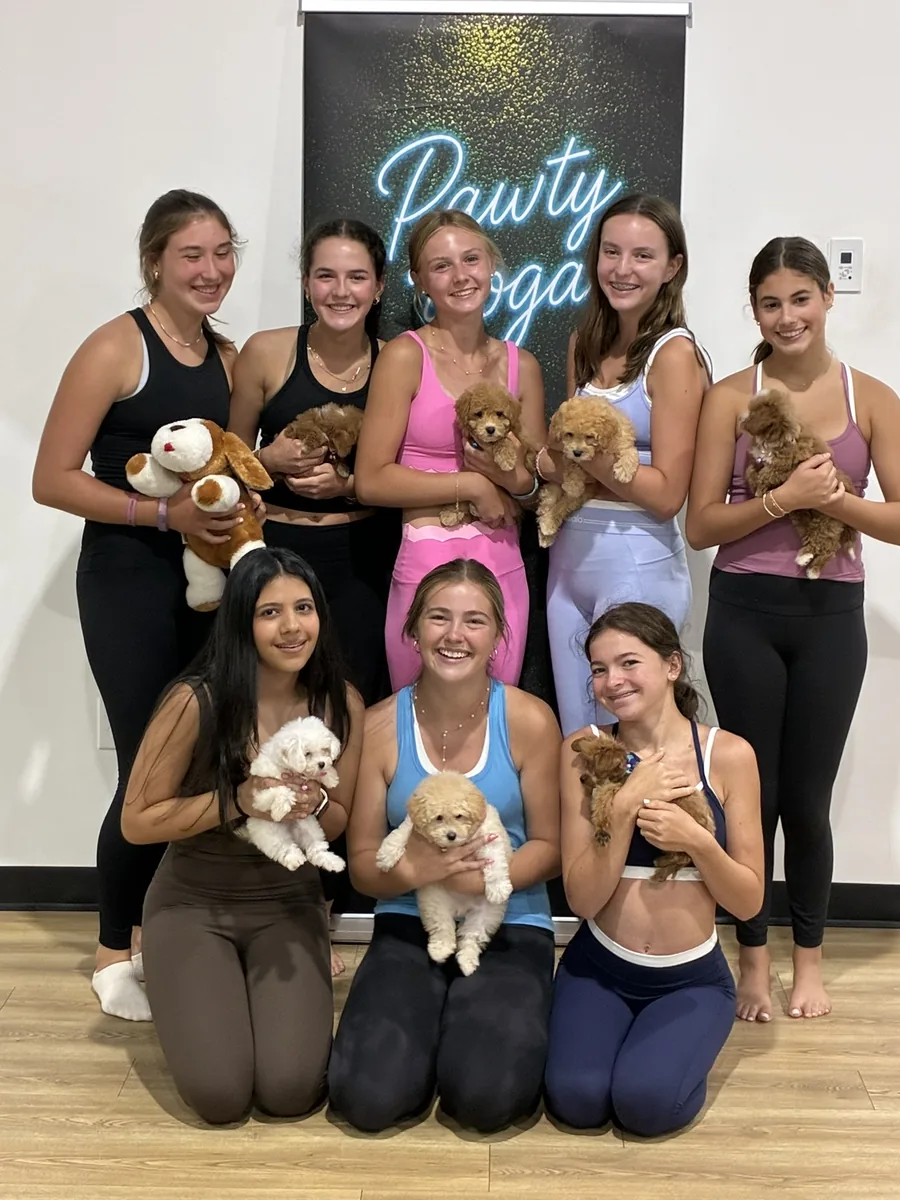 A birthday group with puppies at a private Pawty Yoga party in Houston