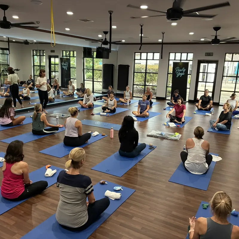 Coworkers on yoga mats with puppies at a Houston corporate puppy yoga event