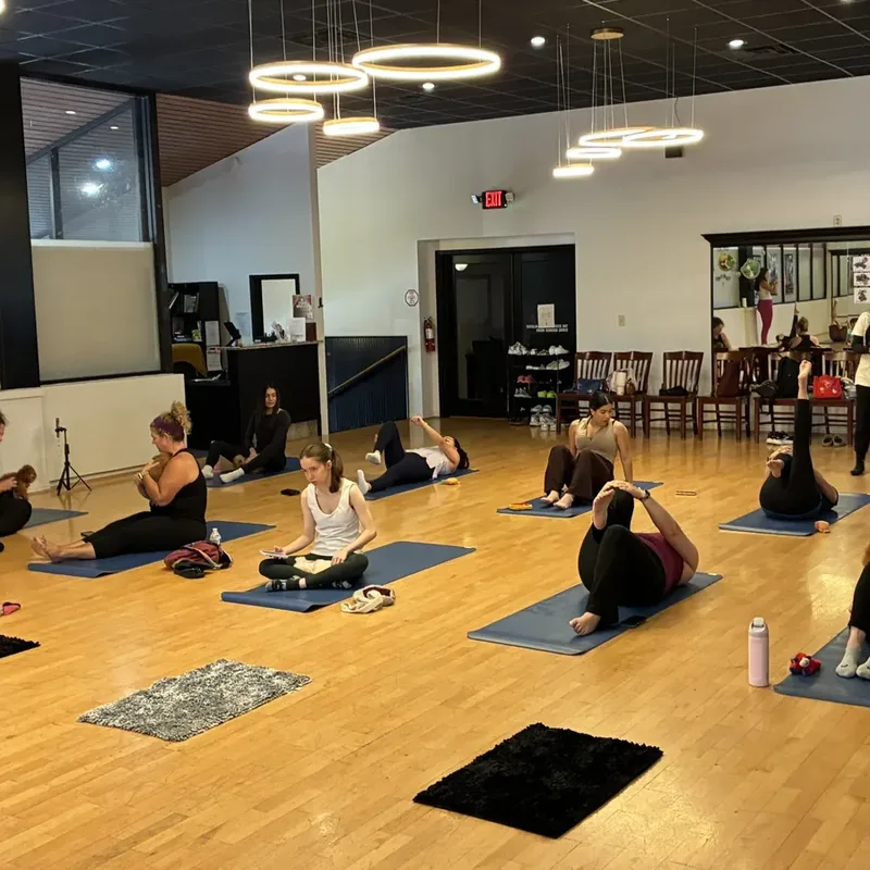 Employees relaxing on mats with puppies during a Houston office puppy yoga class